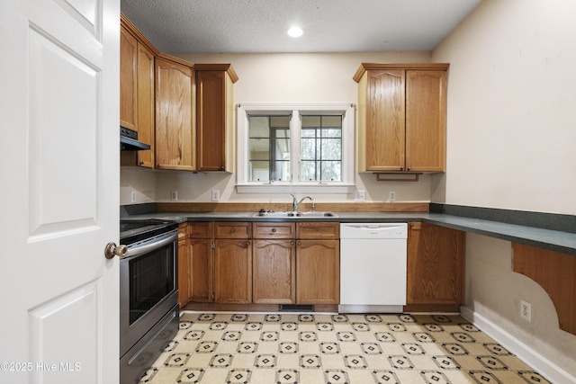 kitchen featuring dishwasher, dark countertops, stainless steel range with electric cooktop, under cabinet range hood, and a sink