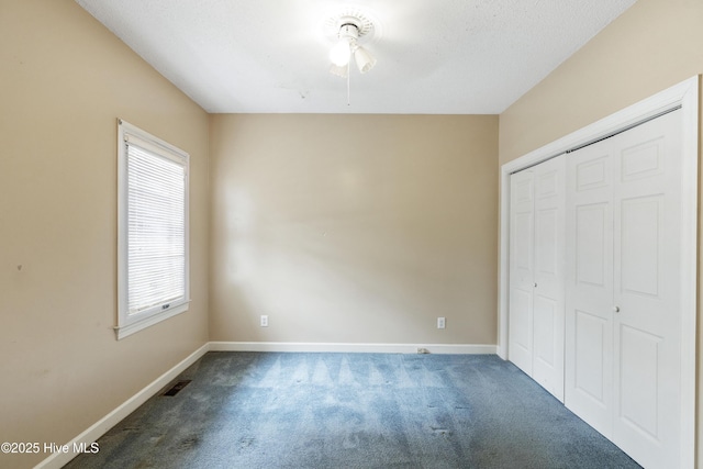 unfurnished bedroom with a closet, carpet, visible vents, and baseboards