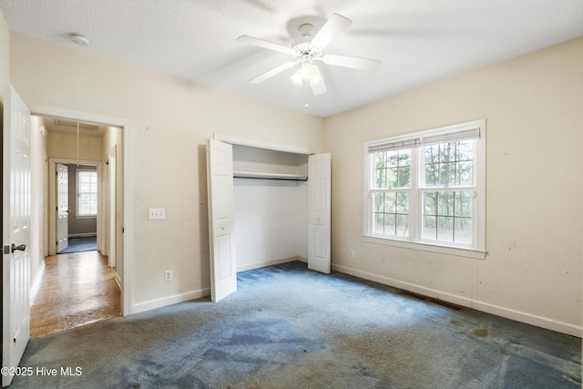 unfurnished bedroom featuring carpet flooring, visible vents, baseboards, a closet, and attic access