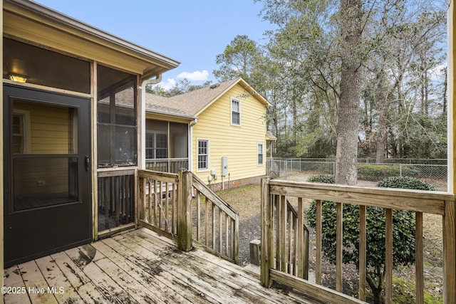 wooden deck with a sunroom and fence