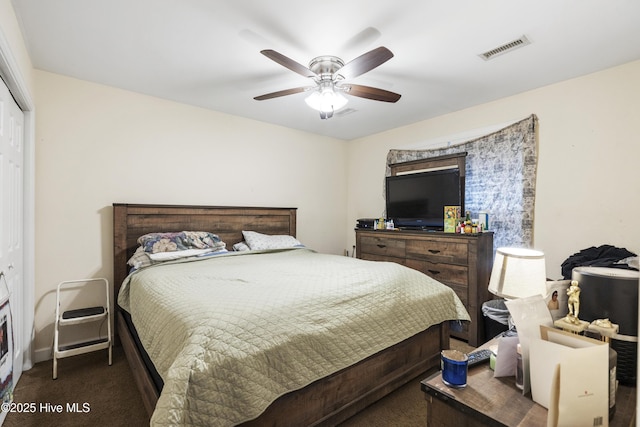 carpeted bedroom featuring a ceiling fan, visible vents, and a closet