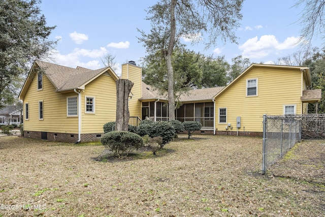 rear view of house featuring crawl space, a chimney, fence, and a sunroom