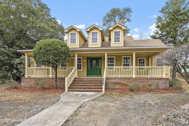 view of front of house with covered porch and a shingled roof