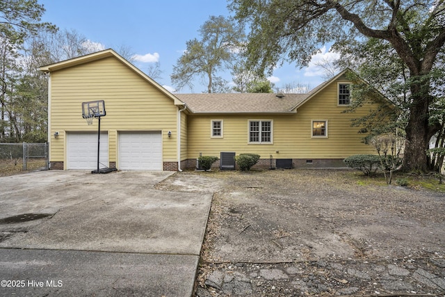 view of front of house featuring roof with shingles, central AC unit, crawl space, fence, and driveway