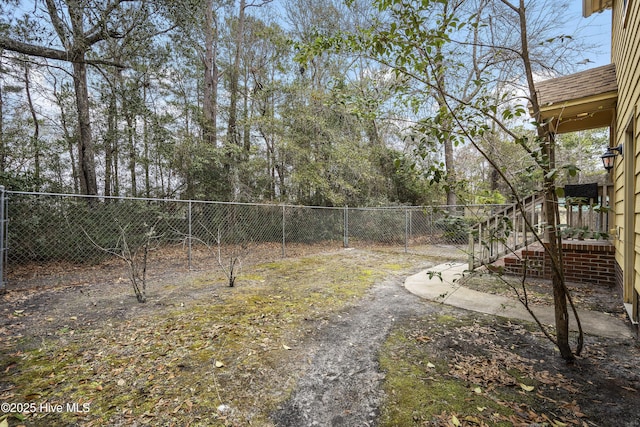 view of yard with fence and stairway