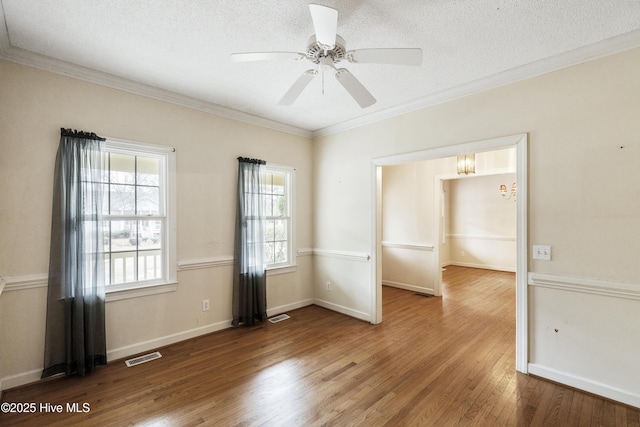 unfurnished room featuring ornamental molding, visible vents, a textured ceiling, and hardwood / wood-style flooring