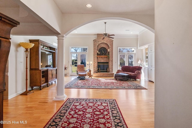 entrance foyer with crown molding, a fireplace, recessed lighting, light wood-style flooring, and ceiling fan