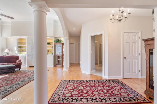 entryway with light wood-type flooring, ornate columns, baseboards, and a ceiling fan