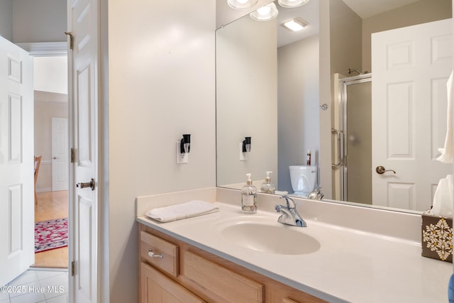 full bathroom featuring a stall shower, tile patterned flooring, and vanity