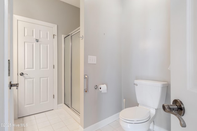 full bath featuring toilet, a stall shower, tile patterned flooring, and baseboards