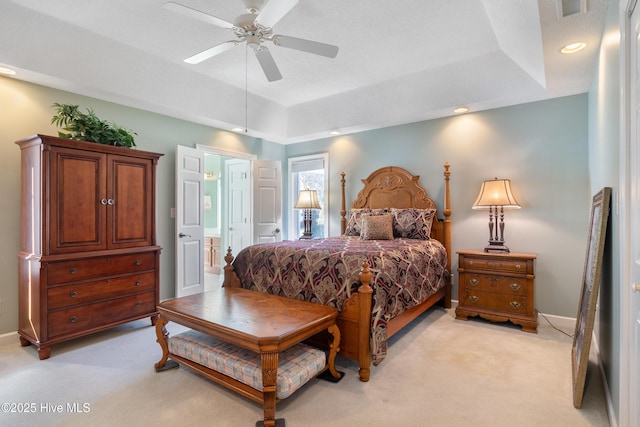 bedroom featuring light carpet, baseboards, a ceiling fan, a tray ceiling, and recessed lighting