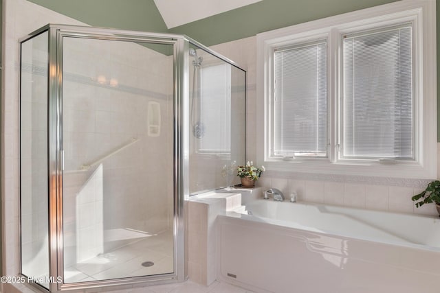 bathroom featuring a garden tub and a shower stall