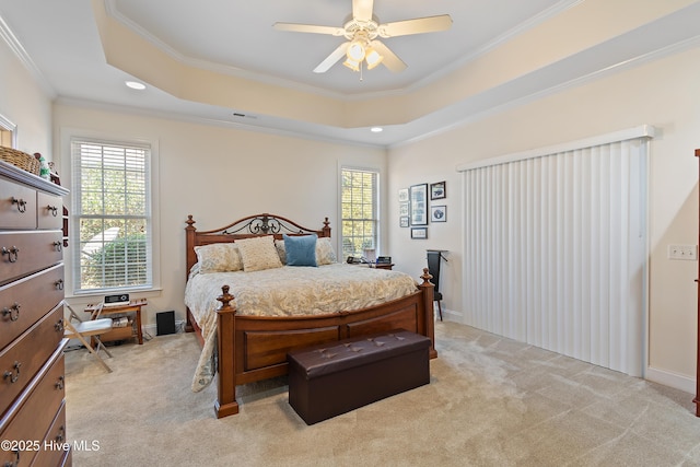 bedroom featuring visible vents, a raised ceiling, a ceiling fan, light colored carpet, and ornamental molding