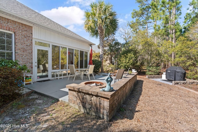 view of patio / terrace featuring an outdoor fire pit, a sunroom, and grilling area