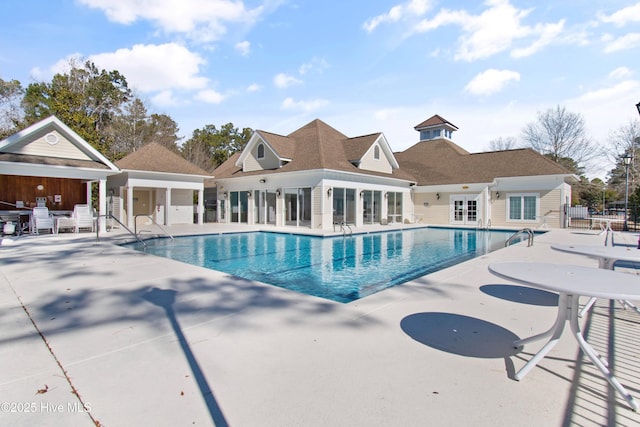 community pool with a patio and fence