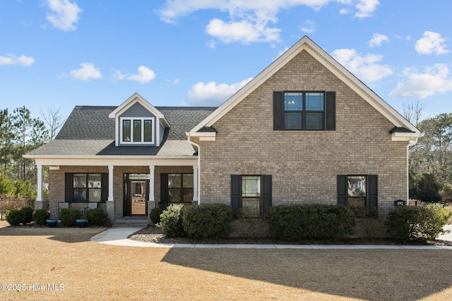 view of front of home featuring a porch and brick siding