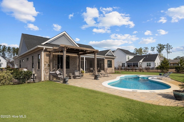 back of house with a yard, a patio area, a fenced in pool, and brick siding