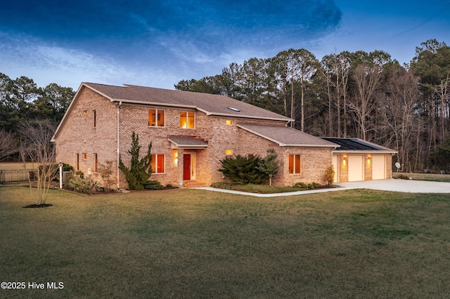 view of front of property featuring a garage, concrete driveway, a front lawn, and brick siding