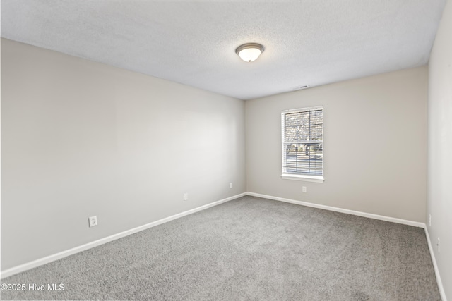 unfurnished room featuring carpet, a textured ceiling, and baseboards