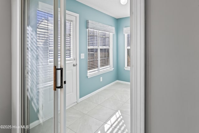 interior space with light tile patterned flooring and baseboards