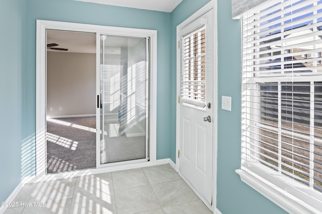 doorway with tile patterned flooring and baseboards