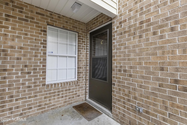 entrance to property featuring brick siding