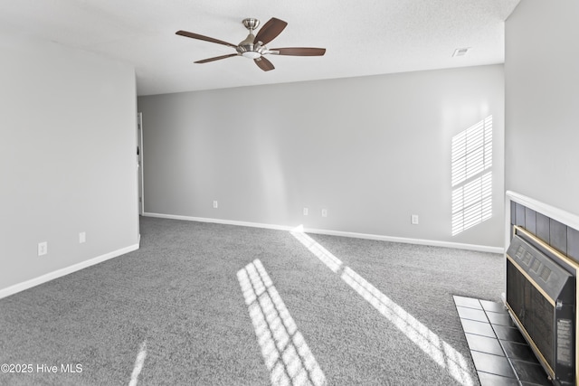 empty room featuring ceiling fan, baseboards, carpet flooring, and heating unit