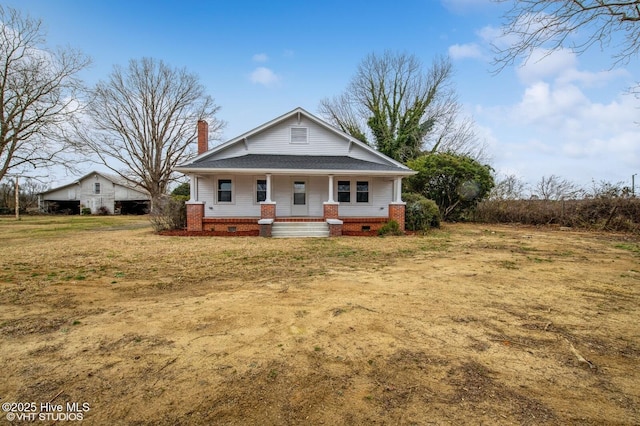 bungalow-style house with crawl space, a porch, a front lawn, and a chimney