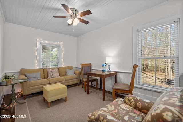carpeted living area with ceiling fan and crown molding