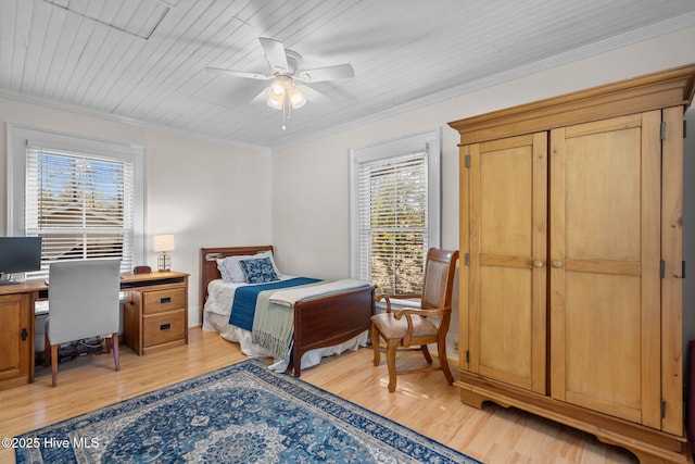 bedroom featuring light wood finished floors, crown molding, and ceiling fan