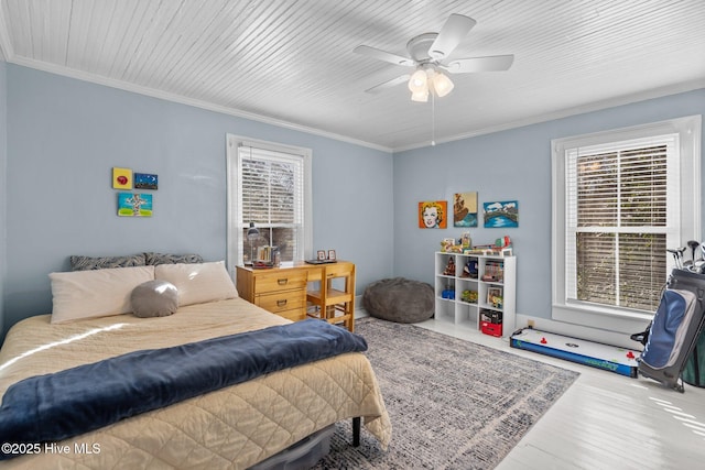 bedroom featuring crown molding, wood finished floors, and a ceiling fan