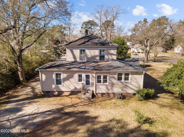 rear view of house with crawl space, a shingled roof, and a chimney