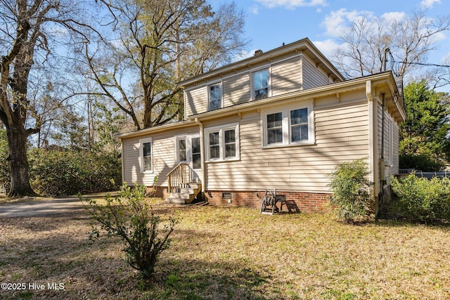 back of house with crawl space, a yard, and entry steps