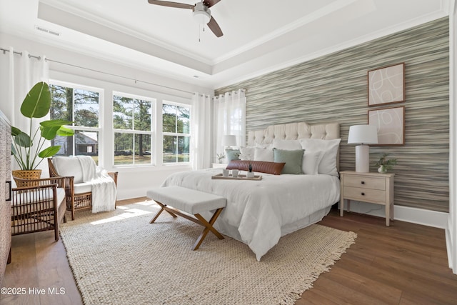 bedroom featuring wallpapered walls, crown molding, baseboards, and a tray ceiling