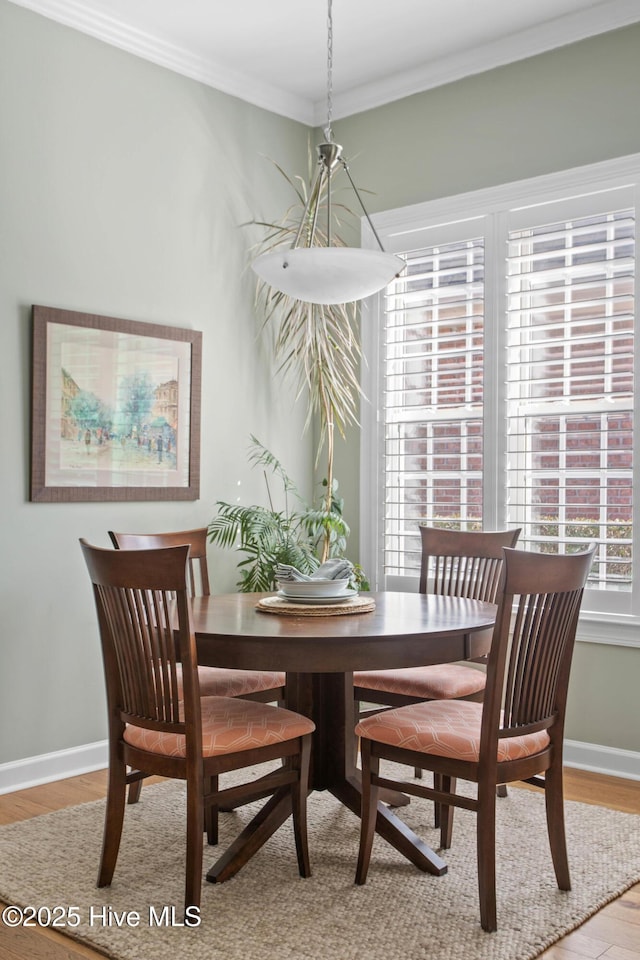 dining room with baseboards, crown molding, and wood finished floors