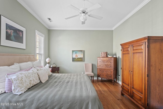 bedroom featuring dark wood-style floors, baseboards, visible vents, and crown molding