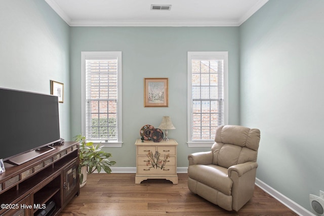 living area featuring a healthy amount of sunlight, visible vents, and wood finished floors