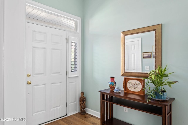 foyer entrance featuring baseboards and wood finished floors