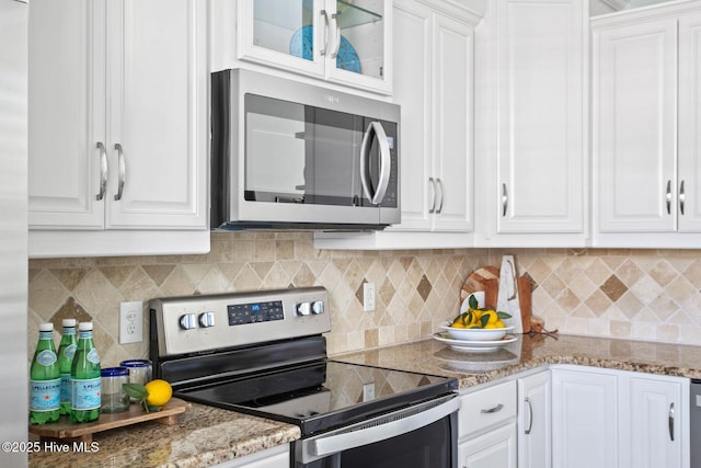 kitchen featuring tasteful backsplash, white cabinetry, and stainless steel appliances