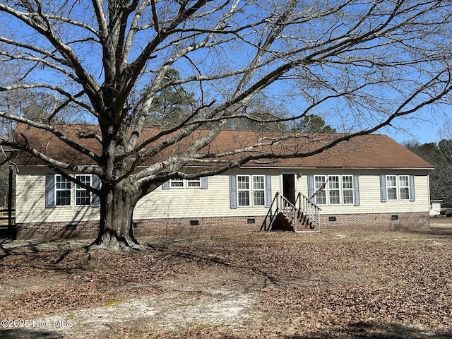 view of front facade featuring a shingled roof and crawl space