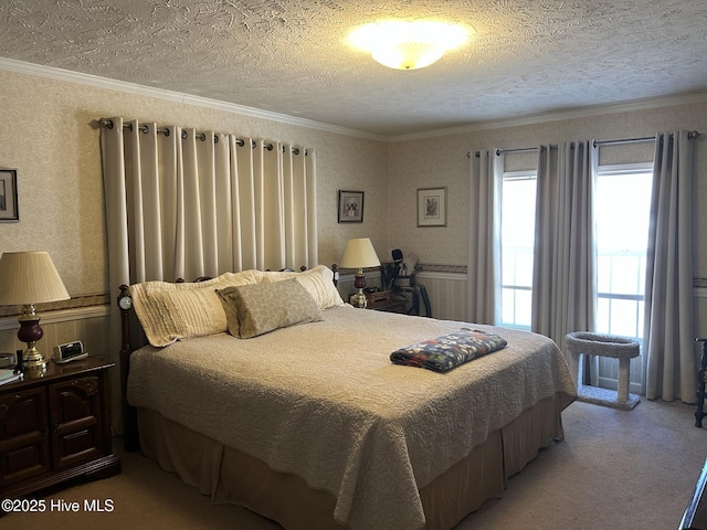 bedroom with ornamental molding, a wainscoted wall, light colored carpet, and a textured ceiling