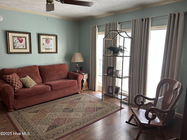 living room with ornamental molding, a wealth of natural light, a textured ceiling, and wood finished floors