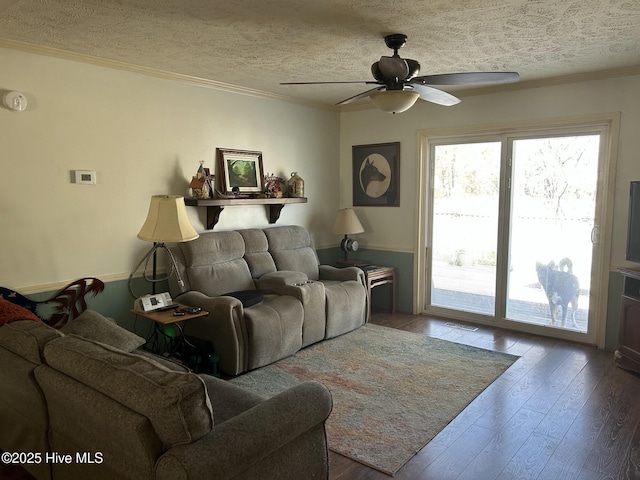 living room featuring a textured ceiling, visible vents, a ceiling fan, hardwood / wood-style floors, and crown molding