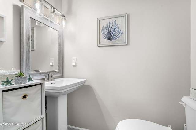 bathroom featuring toilet and baseboards