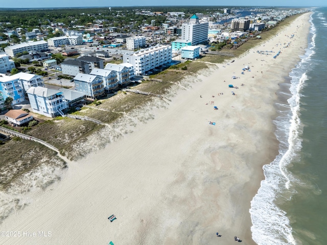 drone / aerial view featuring a water view, a view of city, and a view of the beach