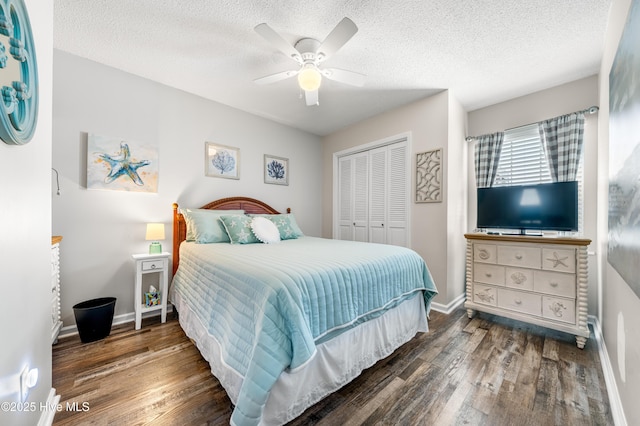 bedroom featuring a textured ceiling, dark wood-type flooring, a closet, and a ceiling fan