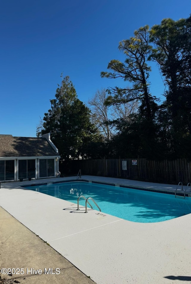 community pool featuring fence and a patio