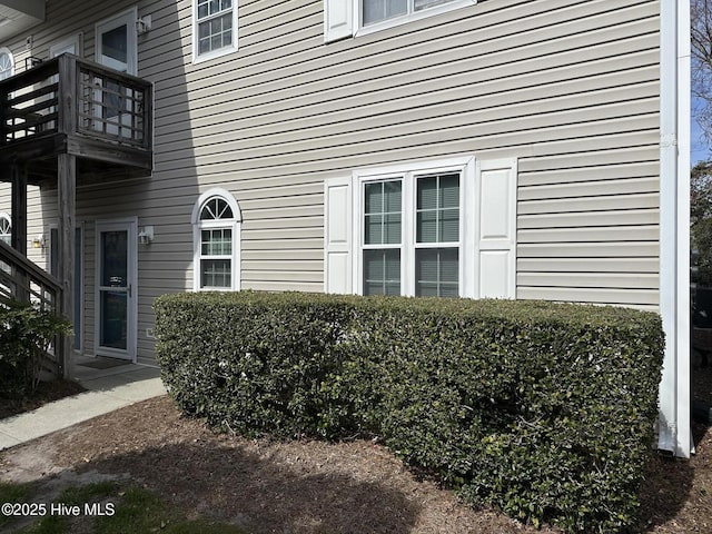 view of exterior entry with a balcony