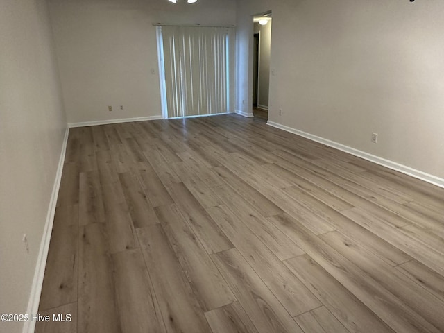 empty room featuring baseboards and wood finished floors