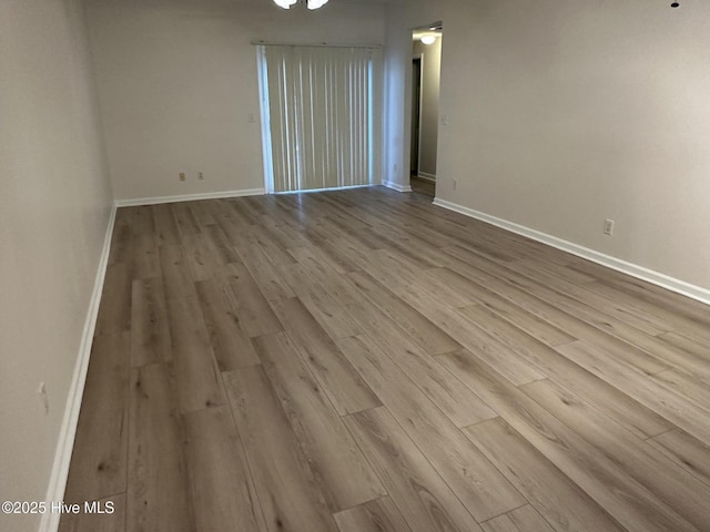 unfurnished room featuring baseboards and wood finished floors